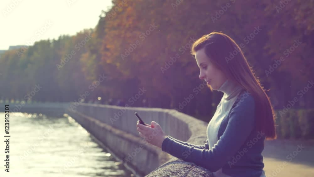 Young woman texting and walking in the park, steadicam shot Young woman texting and walking in the park, steadicam shot