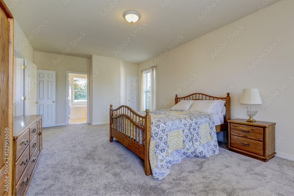 Spacious light tones bedroom with queen size wooden bed Spacious light tones bedroom with queen size wooden bed