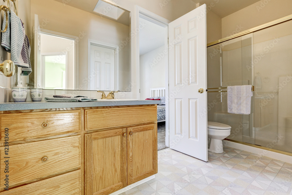 Wooden vanity cabinet, glass shower and a toilet Wooden vanity cabinet, glass shower and a toilet