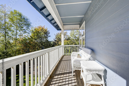 Sunny walkout deck with white wicker furniture