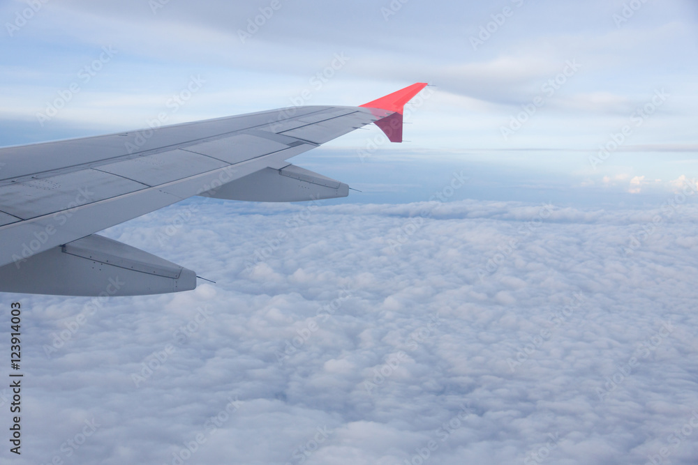 Wing of airplane flying above the clouds .