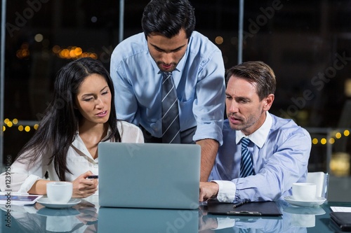 Businesspeople discussing over laptop