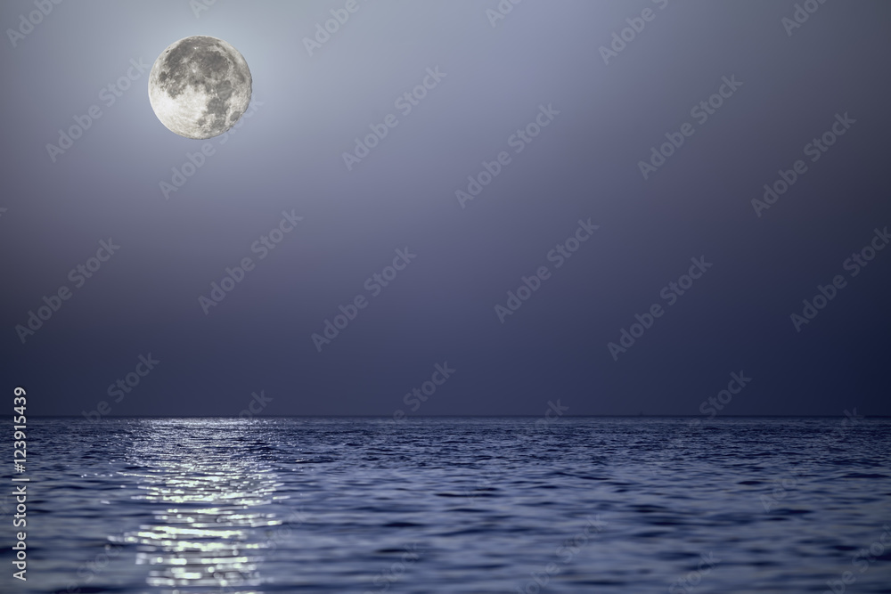 Light from the moon reflecting off a calm blue sea