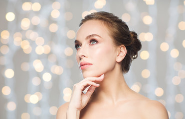 beautiful woman touching her face over lights