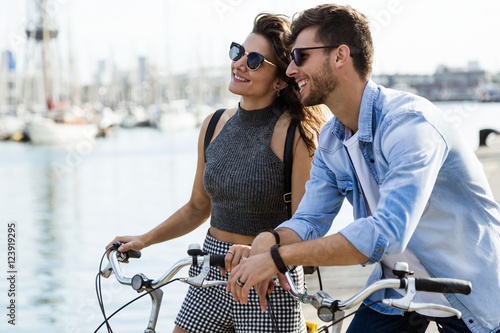 Happy young couple cycling in the city.