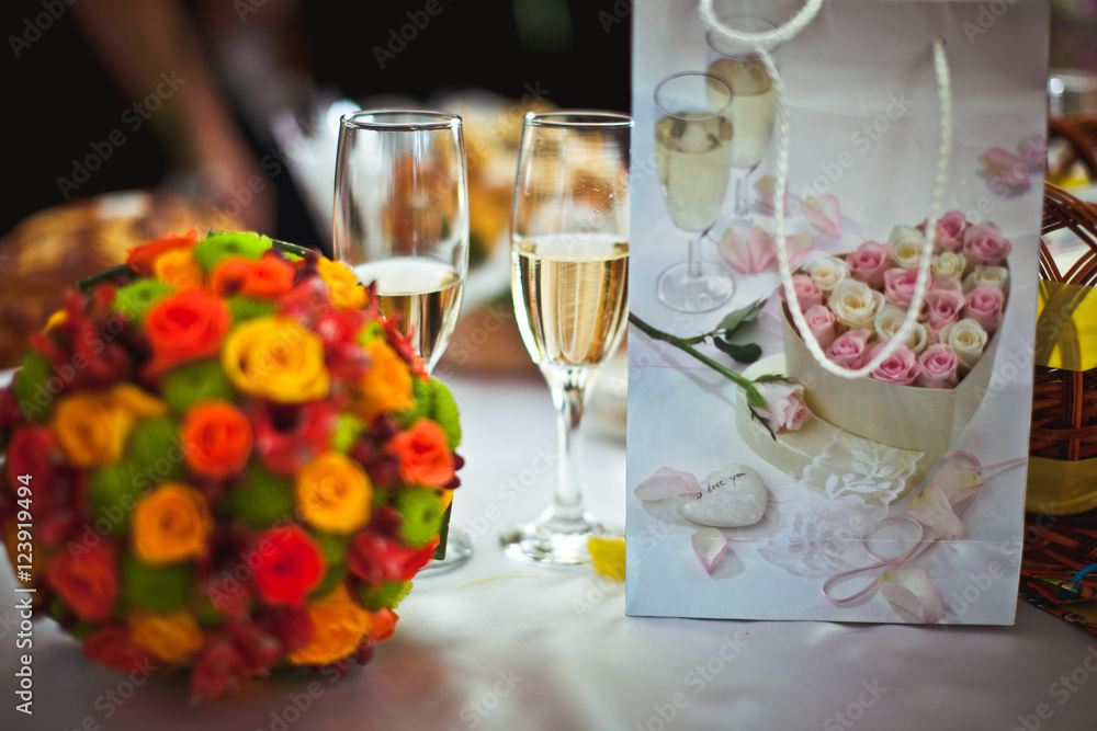 Pretty bright wedding bouquet lies on the table behind the champ Pretty bright wedding bouquet lies on the table behind the champ