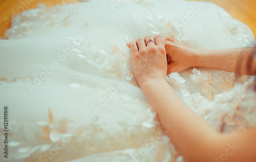 Bride's hands lie closed on the dress