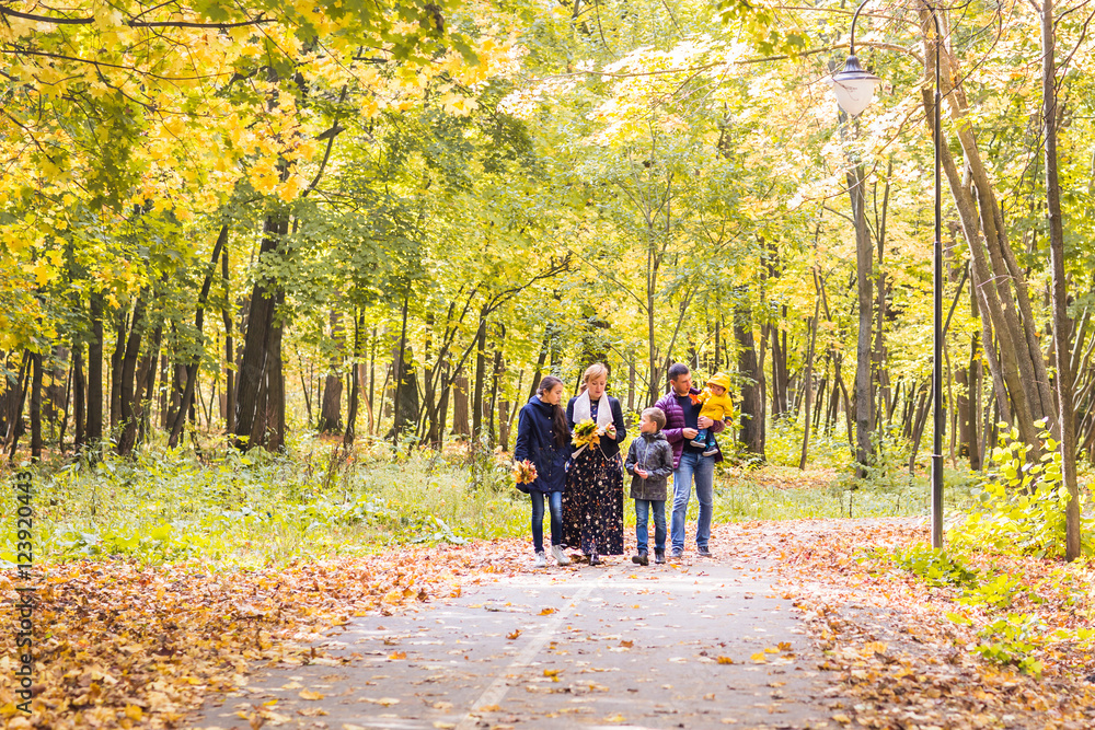 Fototapeta premium Happy young family spending time together outside in autumn nature.