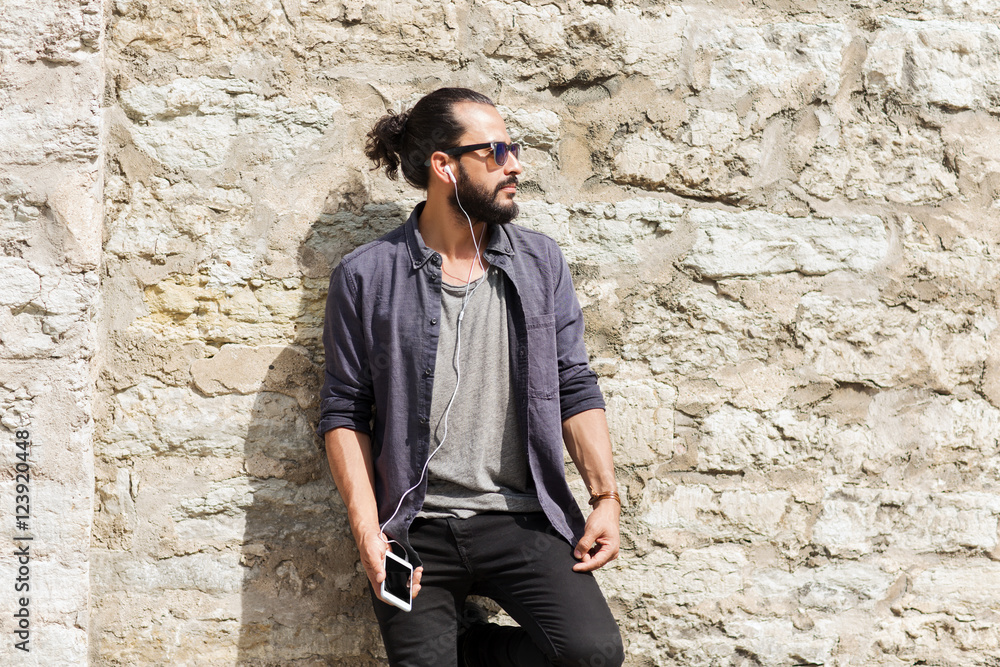 Obraz premium man with earphones and smartphone listening music