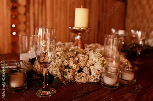 Candles in glasses stand around the white wreath