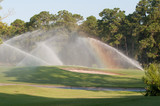 A rainbow formed while watering a beautiful golf course