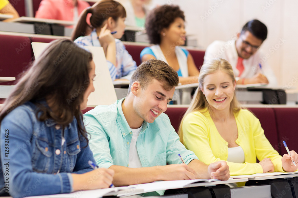 group of students with notebooks in lecture hall group of students with notebooks in lecture hall
