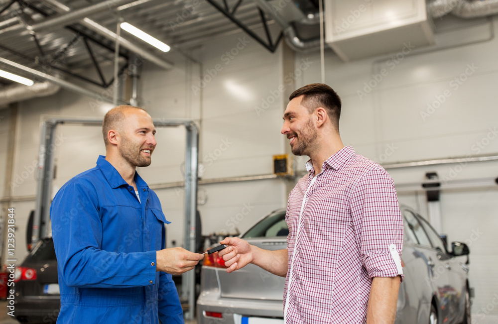 auto mechanic giving key to man at car shop auto mechanic giving key to man at car shop