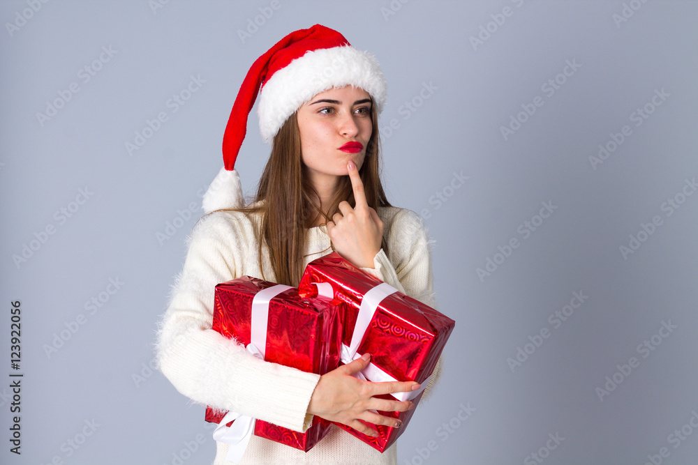 Woman in red christmas hat holding presents Woman in red christmas hat holding presents