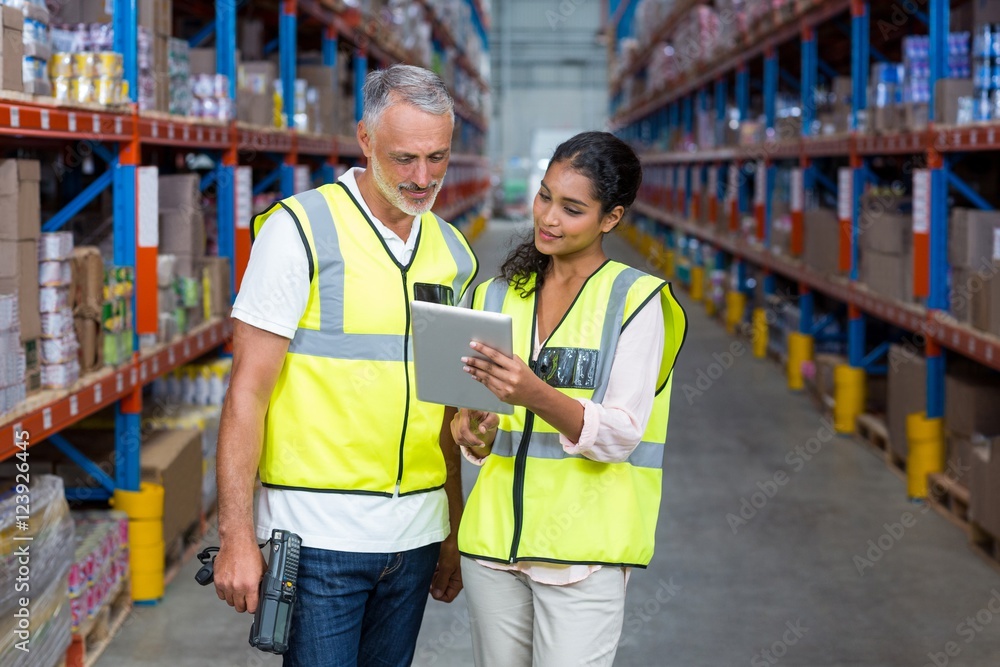 Warehouse workers discussing with digital tablet Warehouse workers discussing with digital tablet