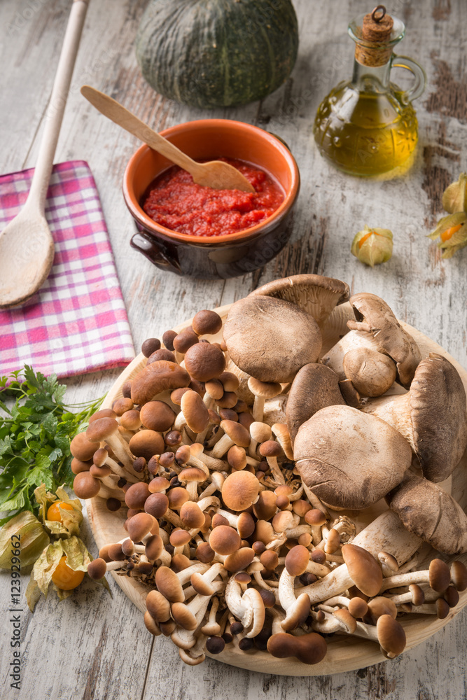Misto di funghi freschi su un piatto tondo in legno su un tavolo Misto di funghi freschi su un piatto tondo in legno su un tavolo