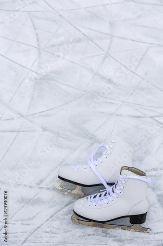 I love ice skating. Ice skates on rink background.