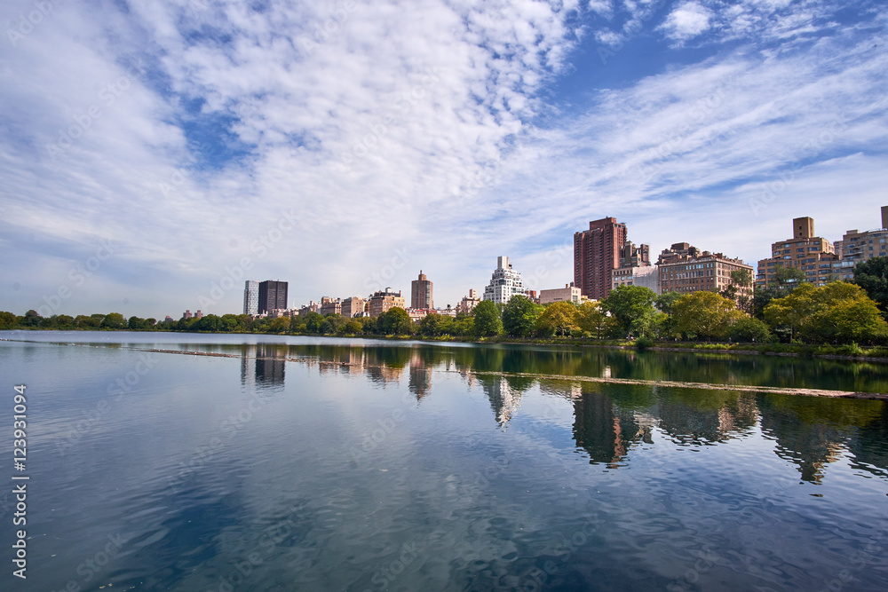 The Jacqueline Kennedy Onassis Reservoir in Central Park with the surrounding apartment buildings mirroring in the calm surface