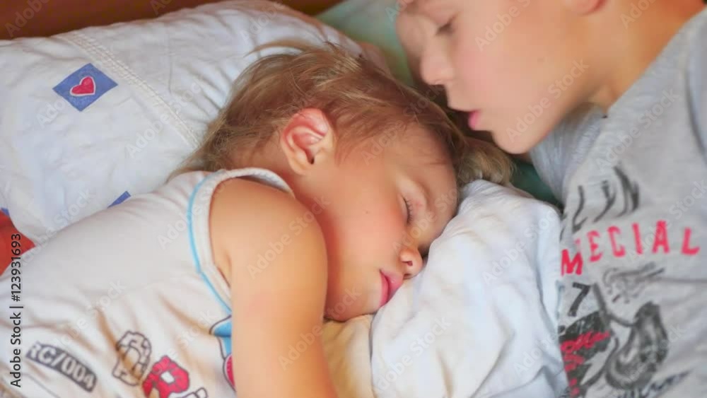 the older brother gently kissed the sleeping younger brother at home the older brother gently kissed the sleeping younger brother at home