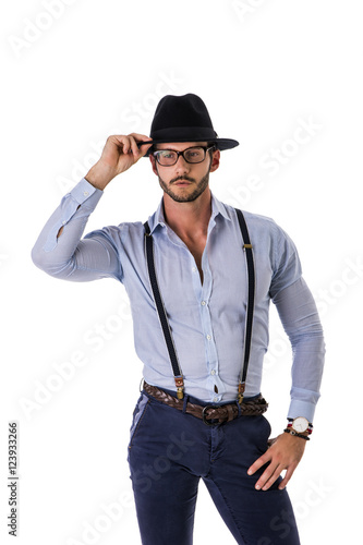 Handsome elegant young man with elegant shirt, suspenders and hat, isolated on white, smiling and looking at camera