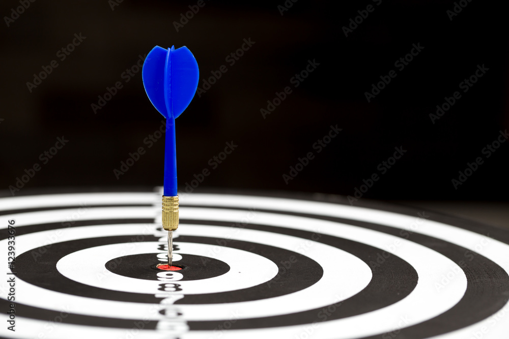 Target dart arrow hitting in the target center of dartboard Target dart arrow hitting in the target center of dartboard