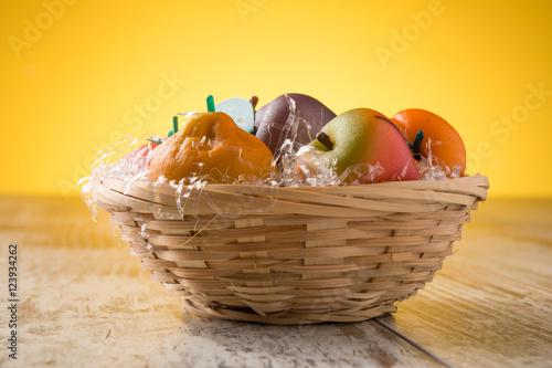 Frutta martorana tipica siciliana colorata in un cestino su un tavolo photo
