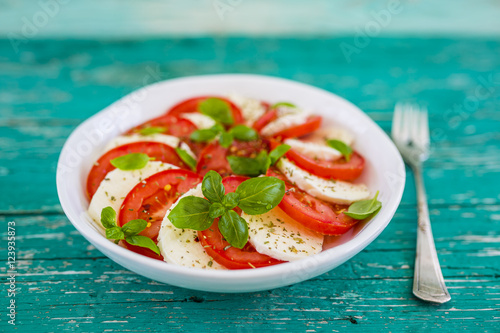 Tableau sur toile Delicious caprese salad with ripe tomatoes and mozzarella cheese with fresh basil leaves
