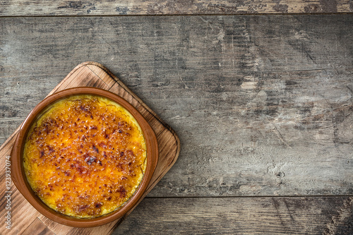 Spanish dessert. Crema catalana on wooden table

 photo