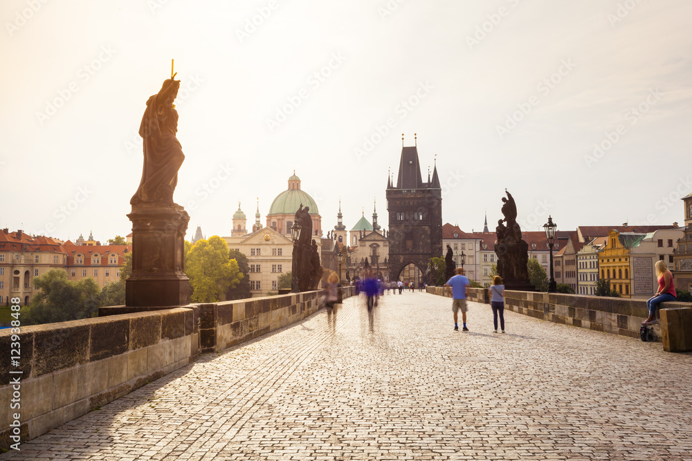 Obraz premium Prague, Czech Republic. Charles Bridge with its statuette, Old Town Bridge Tower, St. Francis Of Assissi Church in the background.