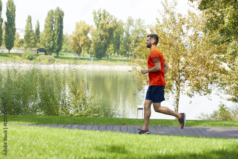 Running is my daily routine. Full length shot of a young man jogging outdoors in the park. Running is my daily routine. Full length shot of a young man jogging outdoors in the park.