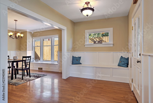 Entrance hall with wood paneled walls and comfortable seat