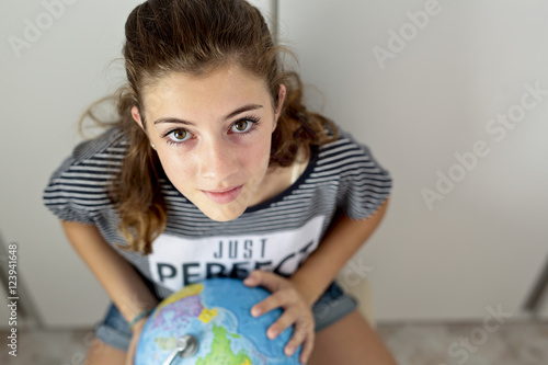 .Teenager with the ball of the world looking for places.