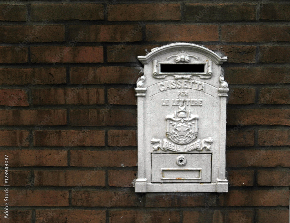 mailbox metal painted in white on a background of red bricks