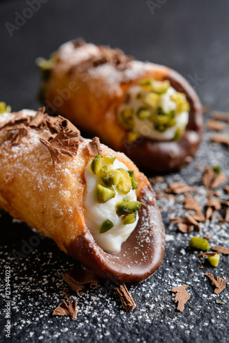 Traditional Sicilian cannoli stuffed with ricotta and pistachios