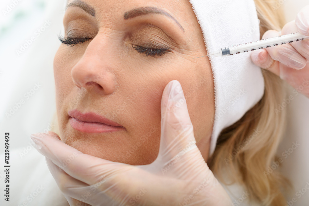Mature woman receiving cosmetic injection procedure