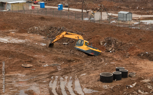 Tablou pe pânză Yellow excavator stuck in the mud at the construction site