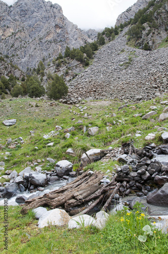 Old wooden bridge over the mountain river photo