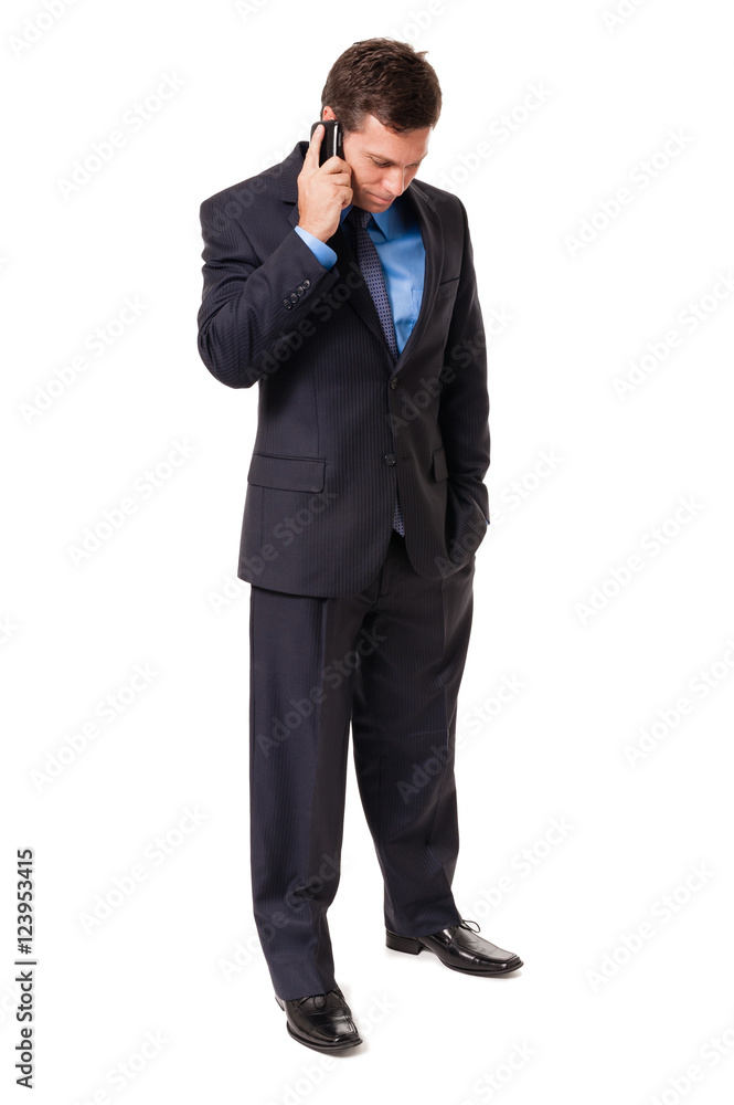 Full-length male man businessman with head down hand in pocket listening talking planning on mobile phone isolated on white background Full-length male man businessman with head down hand in pocket listening talking planning on mobile phone isolated on white background
