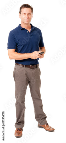 Full-length causal dress male man businessman in blue polo shirt texting with mobile cell phone isolated on white 