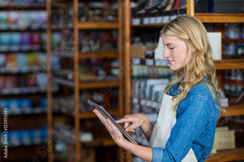 Female staff using digital tablet in supermarket photo