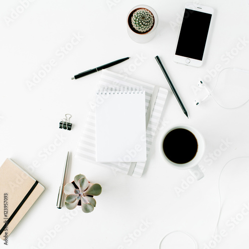 Flat lay, top view office table desk. Workspace with blank diary, headphones, coffee, succulent and watch on white background.