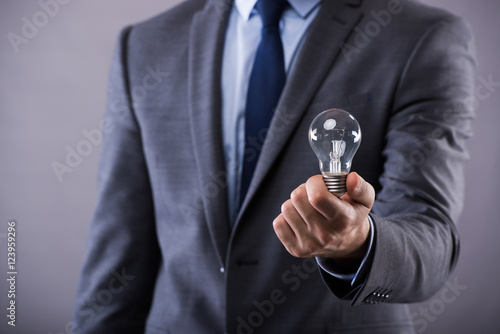 Businessman holding light bulb in creativity concept