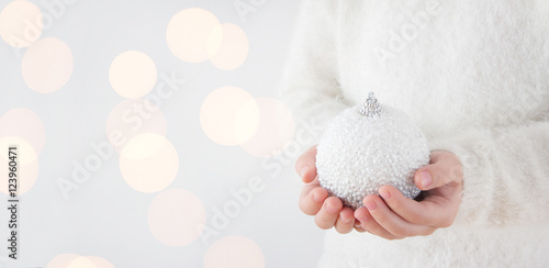 child holding white christmas bauble