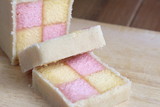 Freshly cut Battenberg Cake with pink and yellow sponge covered in marzipan