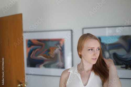 Red Haired Woman in WhiteTop at an Art Gallery