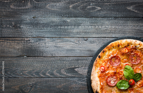 Hot Italian pizza on a rustic wooden table.