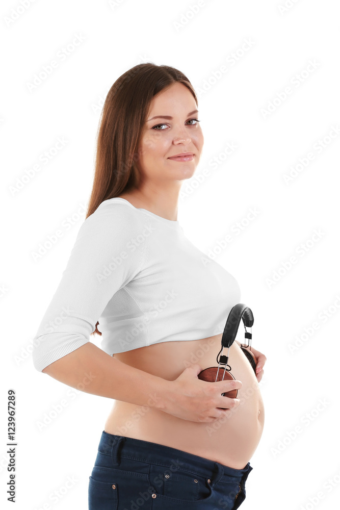 Pregnant woman holding headphones on belly, Stock image