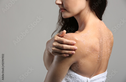 Young woman applying scrub ...