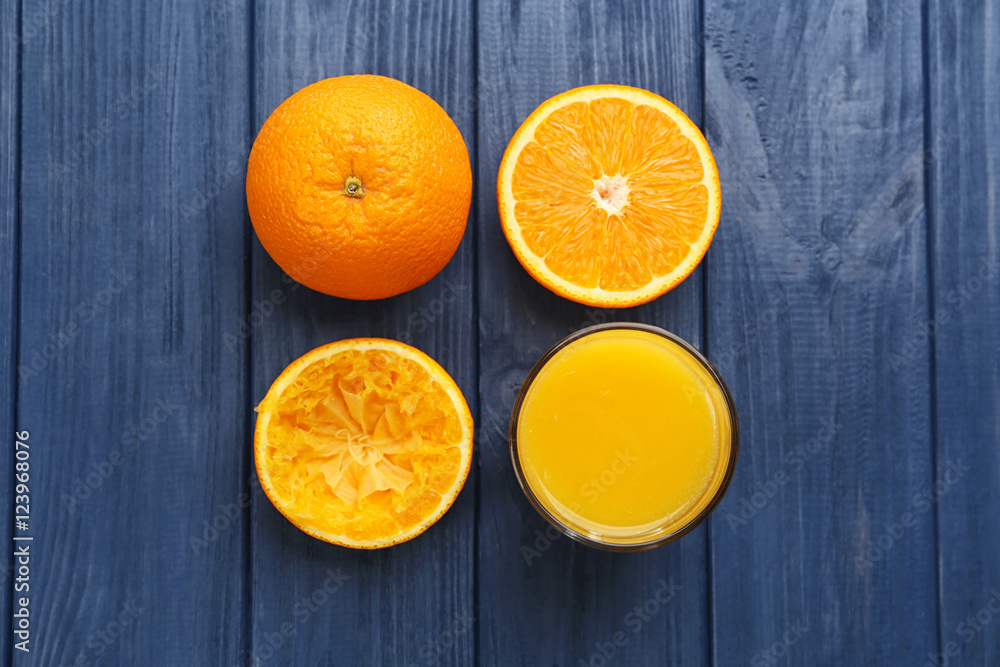 Oranges with juice on wooden table Oranges with juice on wooden table