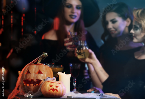 Canvas Print People in costumes near table with Halloween decor